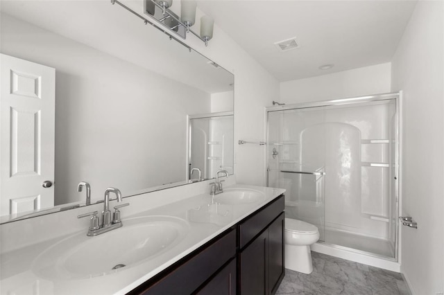 bathroom featuring a shower with door, vanity, and toilet