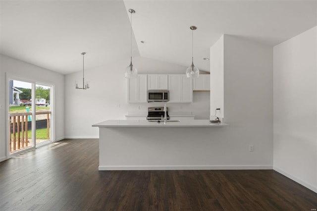 kitchen with stainless steel appliances, kitchen peninsula, pendant lighting, sink, and white cabinetry