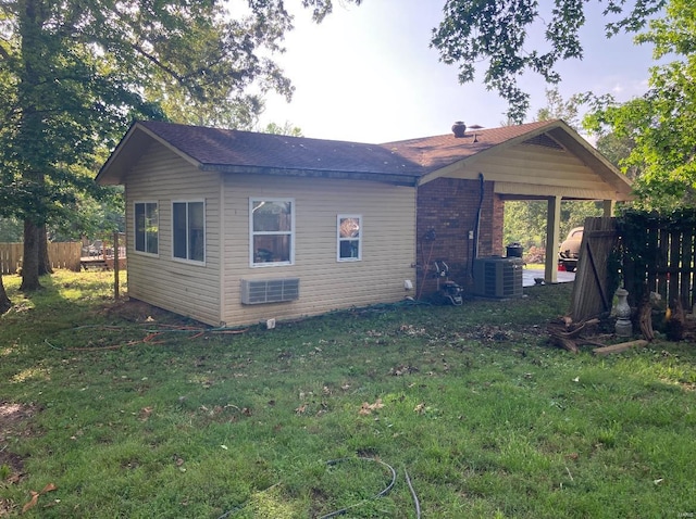 back of house featuring central AC unit and a yard