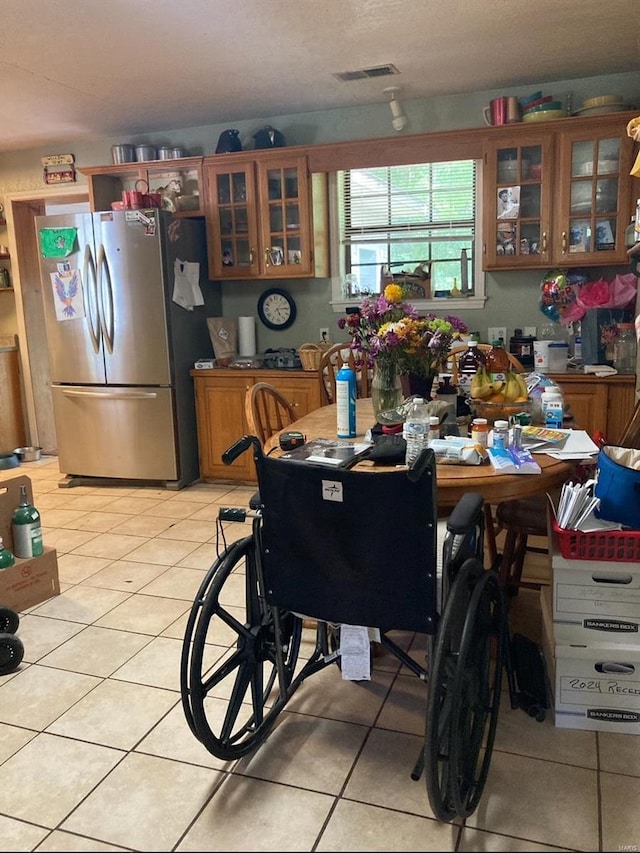 kitchen featuring stainless steel refrigerator and light tile floors