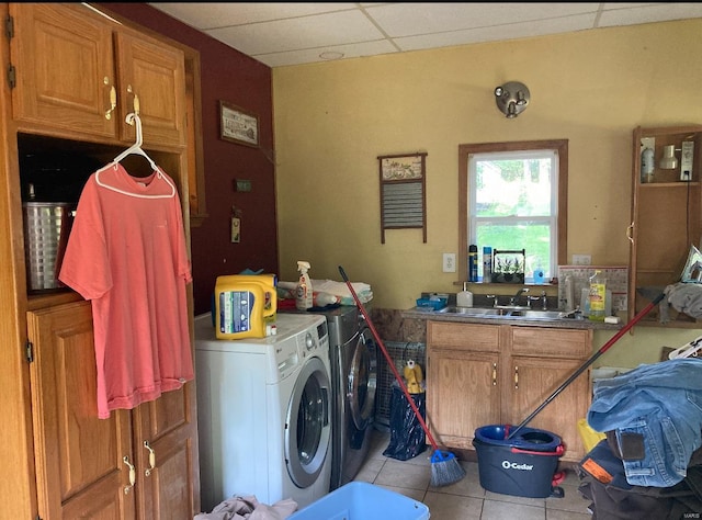 clothes washing area featuring cabinets, sink, independent washer and dryer, and light tile floors