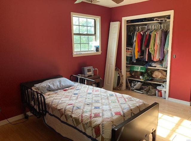 bedroom with hardwood / wood-style floors, a closet, and ceiling fan