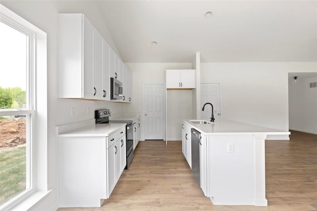 kitchen featuring a center island with sink, light wood-type flooring, white cabinets, appliances with stainless steel finishes, and sink