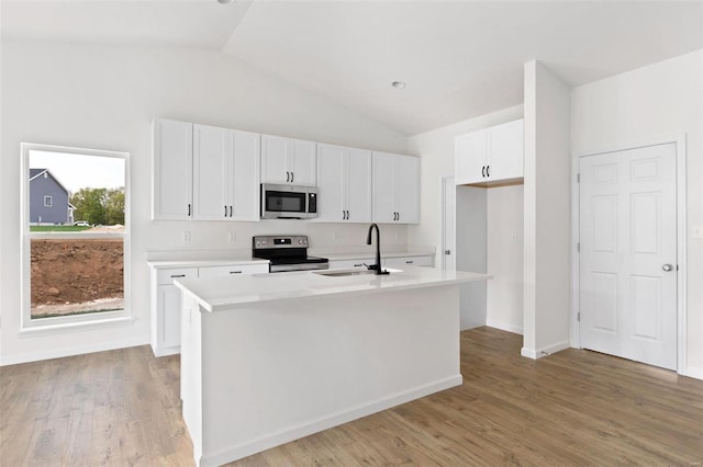 kitchen with stainless steel appliances, a center island with sink, white cabinets, and sink