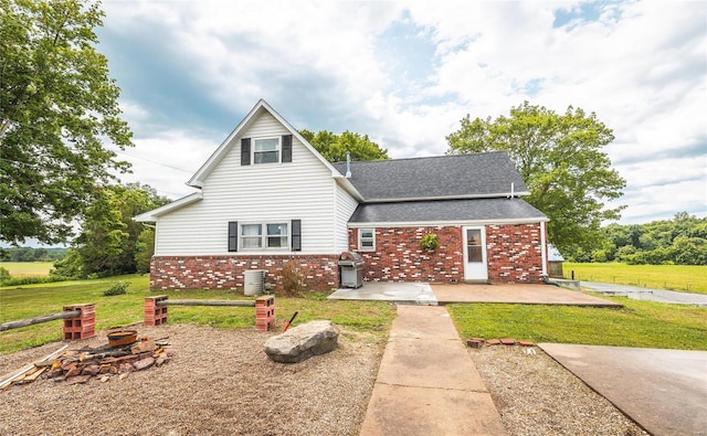 back of house featuring a lawn, central AC unit, and a patio area