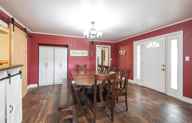 dining space with crown molding, dark hardwood / wood-style floors, and a barn door