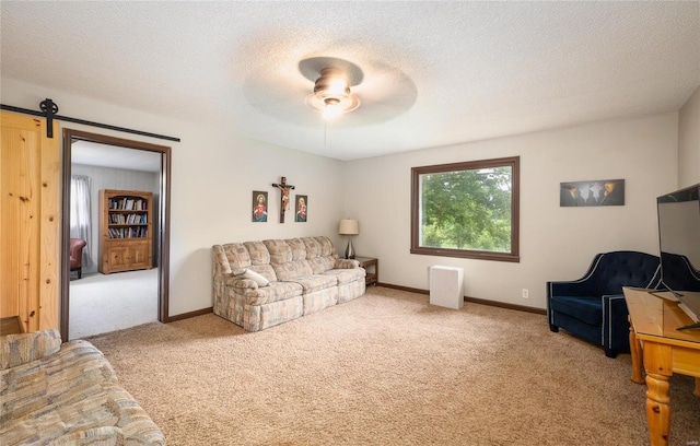 living room featuring radiator heating unit, ceiling fan, a barn door, light carpet, and a textured ceiling