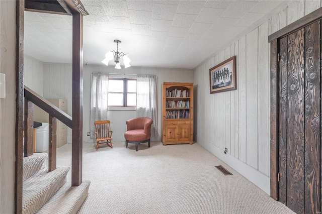 living area featuring an inviting chandelier and carpet