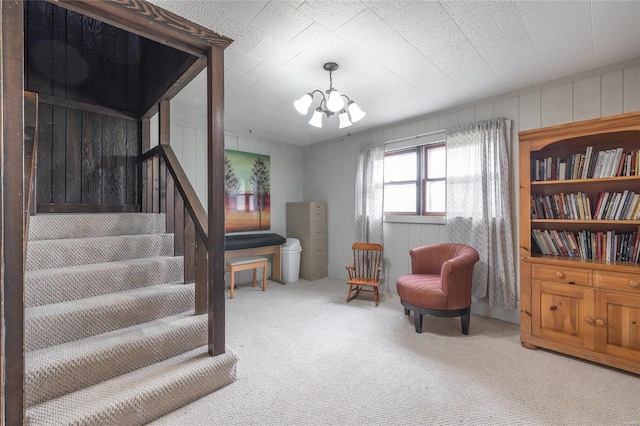 living area featuring an inviting chandelier and carpet floors