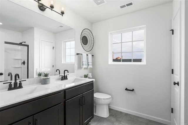 bathroom featuring vanity, a healthy amount of sunlight, toilet, and a shower with door