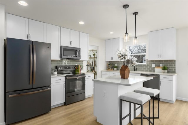 kitchen featuring white cabinetry, light wood-type flooring, and appliances with stainless steel finishes