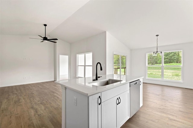 kitchen featuring sink, stainless steel dishwasher, decorative light fixtures, a center island with sink, and white cabinets