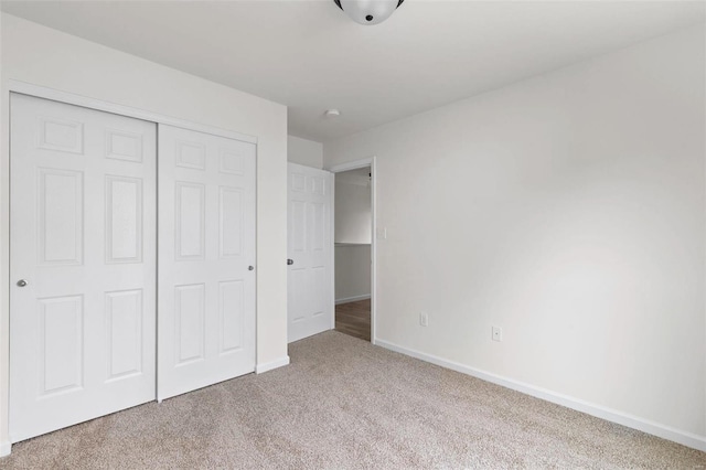 unfurnished bedroom with light carpet and a closet