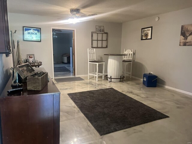 living room with concrete floors, ceiling fan, and a textured ceiling