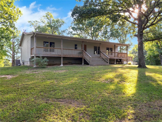 rear view of house with a wooden deck and a yard