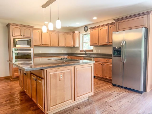 kitchen with light wood-type flooring, a center island, pendant lighting, and stainless steel appliances