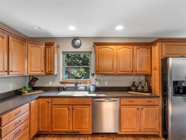 kitchen with sink, stainless steel appliances, and light wood-type flooring