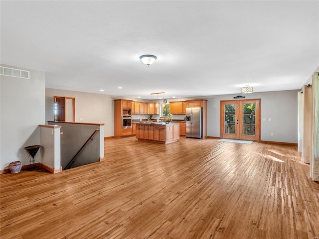 unfurnished living room featuring light hardwood / wood-style flooring and french doors