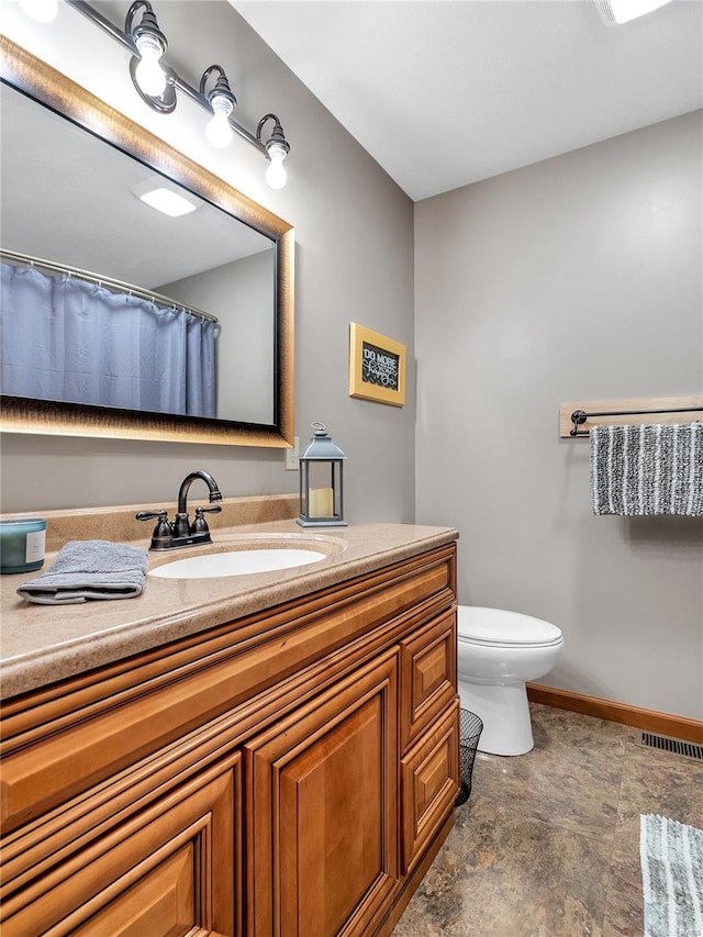 bathroom featuring tile patterned flooring, toilet, and vanity