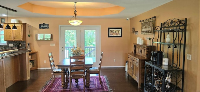 dining space featuring a tray ceiling and dark hardwood / wood-style flooring