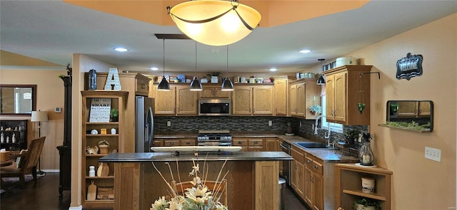 kitchen featuring a center island, stainless steel appliances, hanging light fixtures, decorative backsplash, and sink