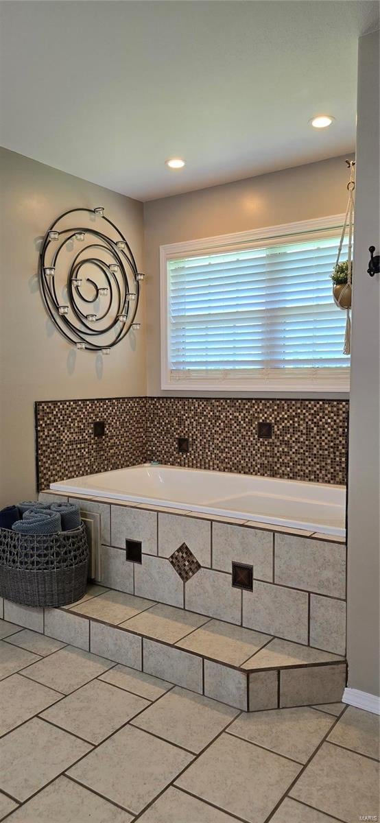 bathroom featuring tile patterned flooring and tiled bath