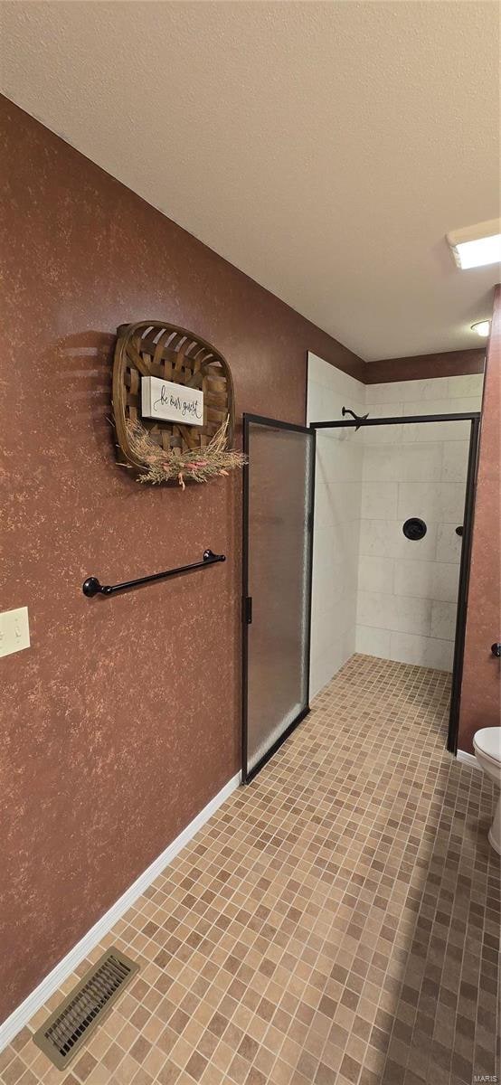 bathroom featuring tile patterned flooring, toilet, and a textured ceiling