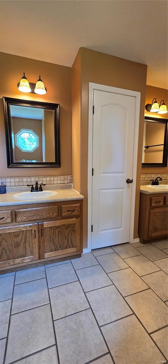 bathroom with tile patterned flooring, tasteful backsplash, and vanity