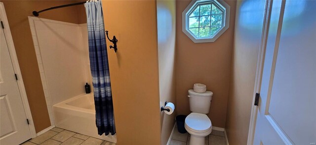 bathroom featuring tile patterned flooring, shower / bath combo with shower curtain, and toilet