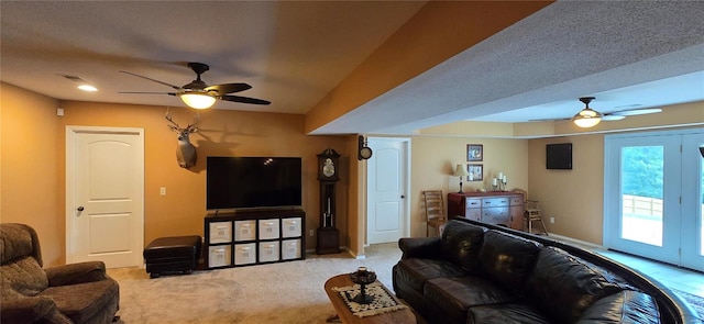 carpeted living room featuring french doors, ceiling fan, and a textured ceiling