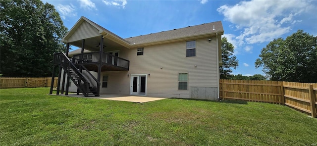 back of property featuring a patio area, a wooden deck, and a lawn