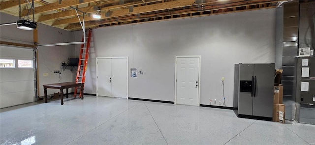 garage featuring stainless steel fridge with ice dispenser and a garage door opener