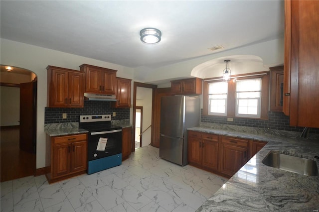 kitchen with decorative backsplash, appliances with stainless steel finishes, sink, and dark stone countertops