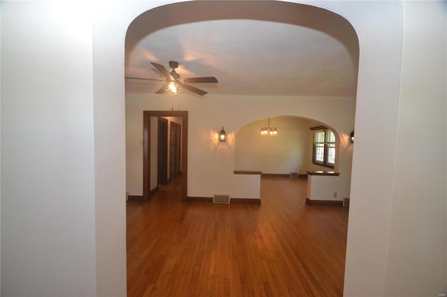 empty room featuring hardwood / wood-style floors and ceiling fan with notable chandelier