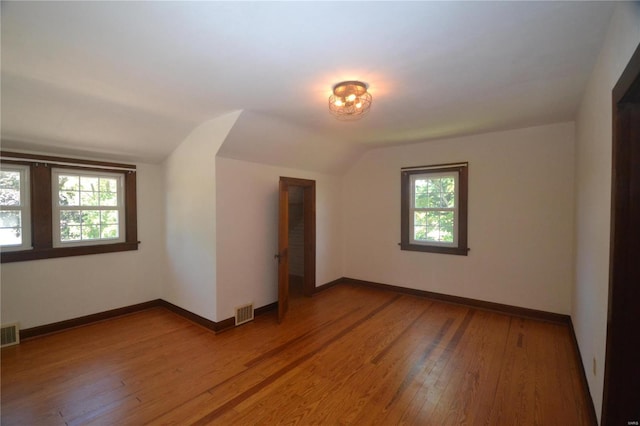 empty room featuring wood-type flooring and lofted ceiling