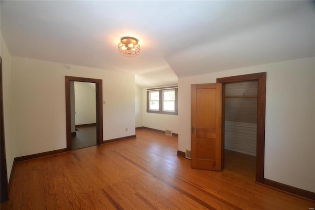 unfurnished bedroom featuring a closet and hardwood / wood-style floors