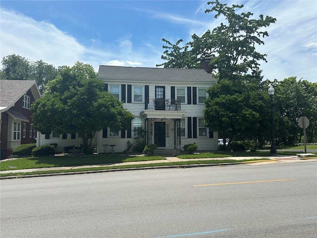 colonial-style house featuring a front lawn