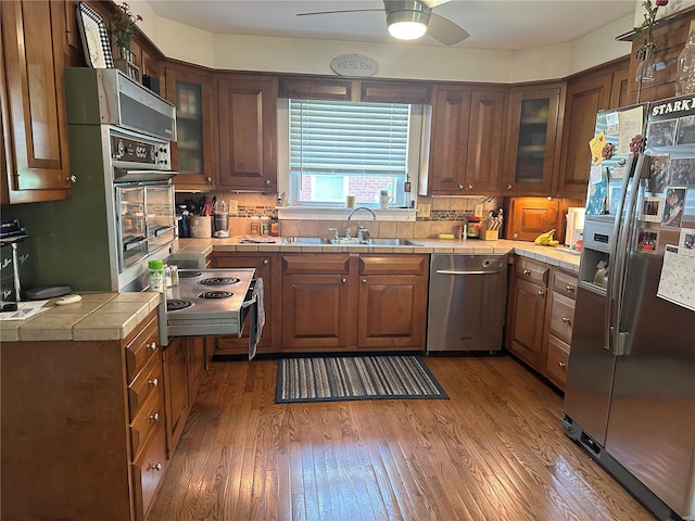 kitchen with tile countertops, stainless steel appliances, and dark hardwood / wood-style floors