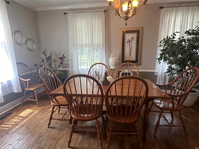 dining area featuring hardwood / wood-style floors, ornamental molding, and a chandelier