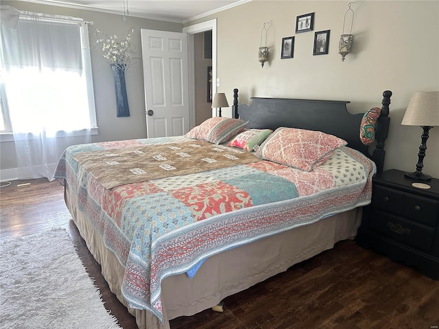 bedroom with dark hardwood / wood-style floors and crown molding