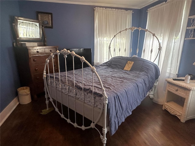 bedroom with crown molding and dark hardwood / wood-style flooring