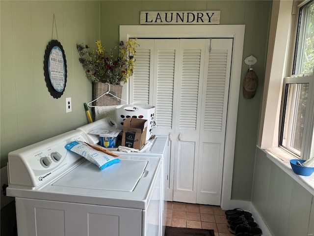 clothes washing area with wooden walls, light tile patterned floors, and independent washer and dryer