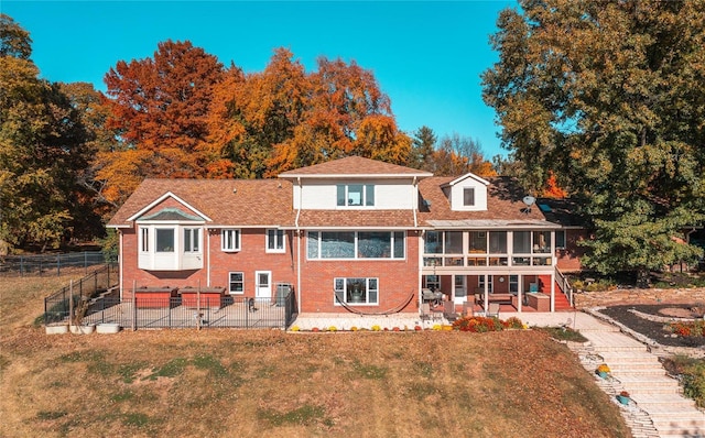 back of house with a patio area, a sunroom, and a yard