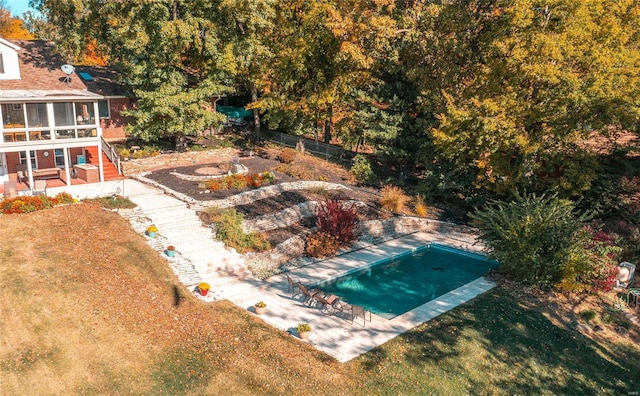 view of pool with a sunroom, a yard, and a patio