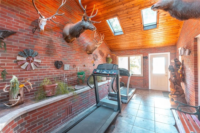 workout room featuring a skylight, wooden ceiling, high vaulted ceiling, brick wall, and tile patterned floors