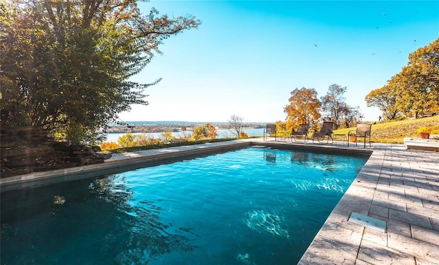 view of pool featuring a water view and a patio area