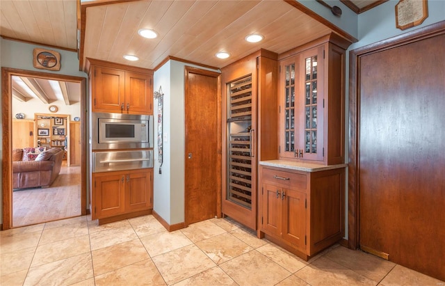 kitchen featuring beam ceiling, stainless steel microwave, wood ceiling, and crown molding