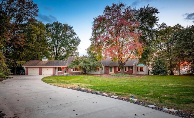 ranch-style home featuring a garage and a front yard