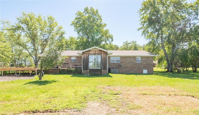 rear view of house with central AC unit and a yard