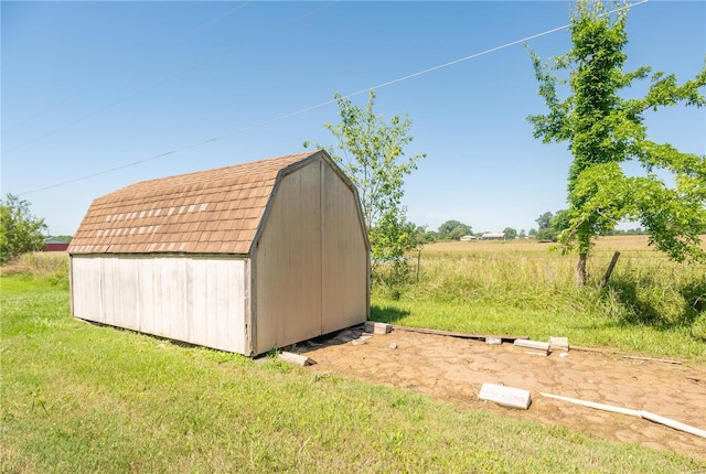 view of outbuilding with a rural view and a lawn